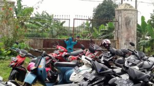 Ibu Penjaga Gerbang dan parkir sepeda motor pengunjung Candi Tridharma